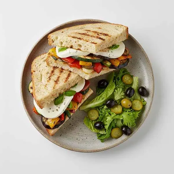 Basil grilled vegetable sandwich with fresh mozzarella & olive gherkin salad  (v)
